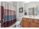 Cozy bathroom featuring a vanity with white porcelain basin, toilet, and tiled shower with curtain at 1197 W Rolls Rd, San Tan Valley, AZ 85143