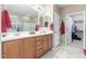 Bright bathroom features a double vanity, framed mirrors, and walk-in closet access at 1197 W Rolls Rd, San Tan Valley, AZ 85143