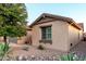View of home showcasing desert landscaping, rocks, and a green tree at 1197 W Rolls Rd, San Tan Valley, AZ 85143