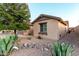 View of home showcasing desert landscaping, rocks, and a green tree at 1197 W Rolls Rd, San Tan Valley, AZ 85143