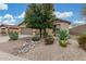 Inviting single-story home showcasing desert landscaping, decorative rocks, and mature trees at 1197 W Rolls Rd, San Tan Valley, AZ 85143