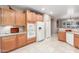 Spacious kitchen with warm wood cabinets, white appliances, and tile flooring at 1197 W Rolls Rd, San Tan Valley, AZ 85143