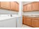 Well-equipped laundry room offers cabinetry, countertop space, and essential washer and dryer units at 1197 W Rolls Rd, San Tan Valley, AZ 85143