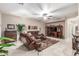 Comfortable living room with tile flooring, ceiling fan, and leather seating arrangement at 1197 W Rolls Rd, San Tan Valley, AZ 85143