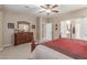 Tastefully designed main bedroom with dresser and adjoining bathroom at 1197 W Rolls Rd, San Tan Valley, AZ 85143
