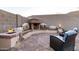 Charming outdoor fireplace with built-in seating, creating a warm and inviting atmosphere at 1197 W Rolls Rd, San Tan Valley, AZ 85143