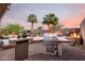 Outdoor kitchen with stainless steel grill and bar area for an exceptional outdoor experience at 1197 W Rolls Rd, San Tan Valley, AZ 85143