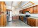 Open kitchen with stainless steel appliances, wood cabinets, granite countertops, and tile floors at 1209 N 87Th St, Scottsdale, AZ 85257