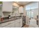 View of kitchen with stainless steel dishwasher, white cabinets, and open to the living room at 12438 N Saguaro Blvd # 108, Fountain Hills, AZ 85268