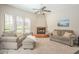 Cozy living room with a fireplace, comfortable seating, and natural light from large windows at 12438 N Saguaro Blvd # 108, Fountain Hills, AZ 85268