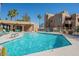 Community pool with clear blue water, lounge chairs, and tropical landscaping at 12438 N Saguaro Blvd # 108, Fountain Hills, AZ 85268