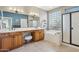 Elegant bathroom featuring a double vanity, a soaking tub next to a glass block window, and a glass-enclosed shower at 12915 W Micheltorena Dr, Sun City West, AZ 85375
