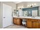 Stylish bathroom with a double vanity, a white countertop, and a view into the adjacent room through a mirror at 12915 W Micheltorena Dr, Sun City West, AZ 85375