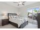 Bright bedroom with a dark headboard bed, large window offering natural light, and a minimalistic decor at 12915 W Micheltorena Dr, Sun City West, AZ 85375