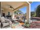 Relaxing covered patio featuring comfortable seating, a ceiling fan, and a well-manicured backyard at 12915 W Micheltorena Dr, Sun City West, AZ 85375