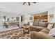 Inviting living room with a brown sectional sofa, patterned rug, and open layout to the kitchen and dining area at 12915 W Micheltorena Dr, Sun City West, AZ 85375