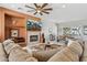 Open-concept living room boasts a fireplace, entertainment center, and seamless flow to dining area at 12915 W Micheltorena Dr, Sun City West, AZ 85375