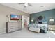 Comfortable main bedroom with a blue accent wall, complemented by a wooden dresser and a door to the bathroom at 12915 W Micheltorena Dr, Sun City West, AZ 85375