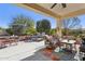 Inviting covered patio with comfortable seating, dining area, and lush landscaping perfect for outdoor enjoyment at 12915 W Micheltorena Dr, Sun City West, AZ 85375