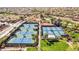 A view of multiple tennis courts ready for friendly matches in a community with lush landscaping and palm trees at 12915 W Micheltorena Dr, Sun City West, AZ 85375