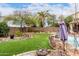 Landscaped backyard with artificial turf, a built in rock fire pit, and seating area with mountain views at 13331 W Romain Ct, Litchfield Park, AZ 85340