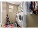 Efficient laundry room with new front-load washer and dryer, shelving, and ample lighting at 13331 W Romain Ct, Litchfield Park, AZ 85340