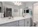 Bright bathroom showcasing a large mirror, double sinks, and modern fixtures at 14175 W Bronco Trl, Surprise, AZ 85387
