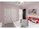 This bedroom includes a sliding closet door, and pink walls at 14175 W Bronco Trl, Surprise, AZ 85387