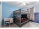 A bedroom with blue walls and a gray bunk bed is well-lit by a ceiling fan at 14175 W Bronco Trl, Surprise, AZ 85387