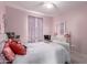 This bedroom has a pink color scheme with light wood floors and a white ceiling fan at 14175 W Bronco Trl, Surprise, AZ 85387