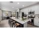 Open concept kitchen with white cabinetry, stainless appliances, and a large island with barstool seating at 14175 W Bronco Trl, Surprise, AZ 85387