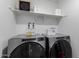 Modern laundry room equipped with front-loading washer and dryer and custom cabinetry for storage at 14175 W Bronco Trl, Surprise, AZ 85387