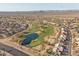 Aerial view of the golf course community with pond surrounded by well-manicured green fairways at 14218 W Via Montoya --, Sun City West, AZ 85375