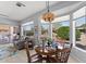 Dining room features large windows, a stylish chandelier, and a sliding door leading to a patio at 14218 W Via Montoya --, Sun City West, AZ 85375