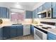 Bright kitchen features blue cabinets, white countertops, and stainless steel appliances at 14218 W Via Montoya --, Sun City West, AZ 85375