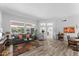 Bright living room with wood-look flooring, a comfortable sofa, and large windows offering ample natural light at 14218 W Via Montoya --, Sun City West, AZ 85375
