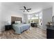 Spacious main bedroom with wood-look floors, ceiling fan, and bright bay windows at 14218 W Via Montoya --, Sun City West, AZ 85375