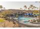 Exterior view of the community pool, which features a zero-entry area, rock waterfall, spa, and shaded seating at 14218 W Via Montoya --, Sun City West, AZ 85375