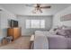 Comfortable bedroom has a wooden dresser, ceiling fan, and inviting bed with lots of pillows at 14875 W Larkspur Dr, Surprise, AZ 85379