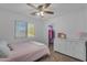 Bedroom featuring a single bed with a dresser, closet, and window, providing a cozy and well-lit space at 14875 W Larkspur Dr, Surprise, AZ 85379
