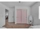 Bedroom featuring pink sliding door closet, window, and a full-length mirror offers a cozy and stylish space at 14875 W Larkspur Dr, Surprise, AZ 85379