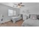 Bright bedroom offers two twin beds, a ceiling fan, window, and white dresser adding a comfortable and stylish touch at 14875 W Larkspur Dr, Surprise, AZ 85379