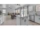 Open-concept kitchen with white cabinets, stainless steel appliances and a view to the dining and living area at 14875 W Larkspur Dr, Surprise, AZ 85379