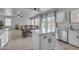 Open-concept kitchen with white cabinets, stainless steel appliances and a view to the dining and living area at 14875 W Larkspur Dr, Surprise, AZ 85379