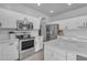 Bright kitchen features white cabinetry, stainless appliances, and white subway tile backsplash at 14875 W Larkspur Dr, Surprise, AZ 85379