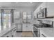 Well-lit kitchen featuring stainless steel appliances, quartz countertops and a view to the backyard at 14875 W Larkspur Dr, Surprise, AZ 85379