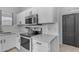 Close-up of the kitchen area featuring quartz countertops, stainless steel appliances and white backsplash at 14875 W Larkspur Dr, Surprise, AZ 85379