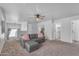 Spacious living room is illuminated by a ceiling fan and includes a comfortable gray sectional couch at 14875 W Larkspur Dr, Surprise, AZ 85379