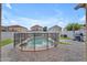 Backyard pool enclosed with a safety fence surrounded by artificial turf and a paved patio at 14875 W Larkspur Dr, Surprise, AZ 85379