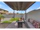 Backyard seating area under a pergola with a fire pit, and landscaped at 14875 W Larkspur Dr, Surprise, AZ 85379